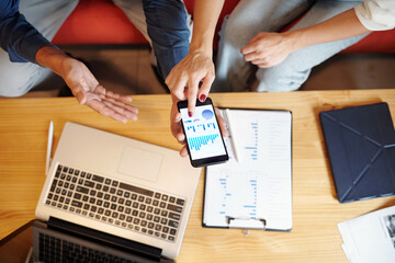 Wall Mural - Hands of business people discussing charts and diagrams on screen of smartphone, view from above