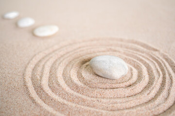 Japanese zen garden stone on wave sand beach. rock or pebbles with copy space. for aroma therapy spa on summer holidays. meditation wellness and tranquility Japanese concept.