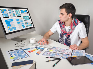 Wall Mural - application development. young designer is engaged in application development. he creates a prototyp