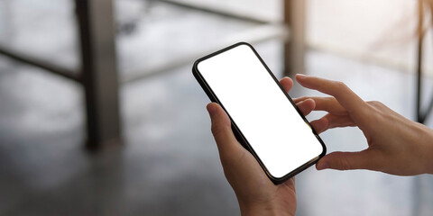 mockup image blank white screen cell phone.women hand holding texting using mobile on desk at home o