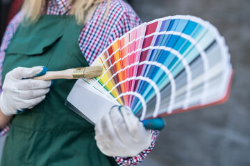 female painter in uniform and helmet with paint charts