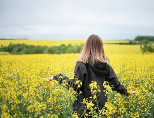 Young girl on yellow rapeseed field