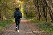 Girl runs along the park alley. Young woman runs away from someone in the park. Lonely girl in forest