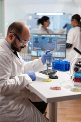 Wall Mural - scientist doing genetic experiment using blood sample on micropipette dropped on petri dish. team of