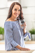 Good-looking woman drinks a glass of pure water inside the house