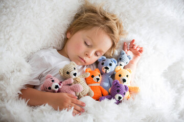 Sticker - Little toddler child, cute blond boy, sleeping with many teddy bears, handmade amigurumi toys at home