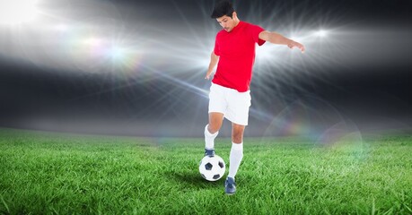 Composition of male football player kicking ball at stadium