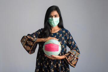 Young girl holding world globe with a medicine face mask. World epidemic of coronavirus concept.