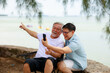 © sutthichai - Happy Asian senior father using smartphone with his son