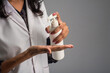 Portrait of woman doctor using a sanitizing gel from a bottle for hands cleaning.