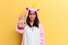 Young Mixed Race Woman Wearing A Unicorn Pajama Isolated On Yellow Background Standing With Outstretched Hand Showing Stop Sign, Preventing You.