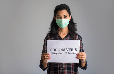 A young woman in a medical mask holding a board of the epidemic of Coronavirus, Covid-19