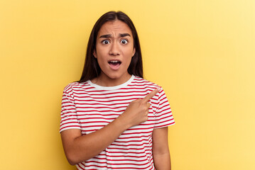 Wall Mural - Young mixed race woman isolated on yellow background pointing to the side