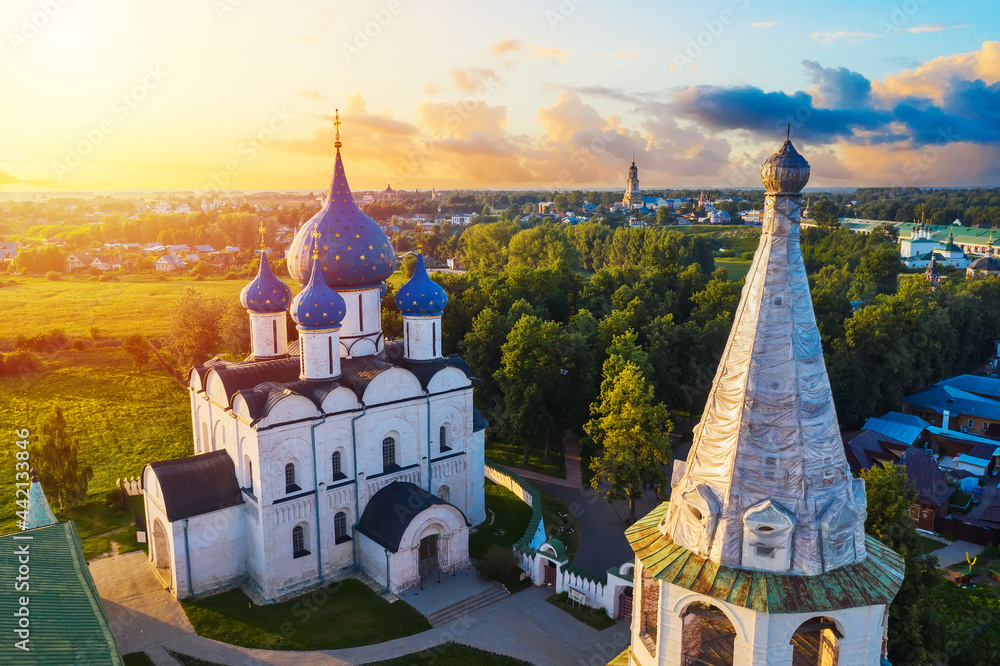 Aerial drone view of Suzdal Kremlin and cathedral of Nativity at the Kamenka river, Russia. Summer sunny day sunset - obrazy, fototapety, plakaty 