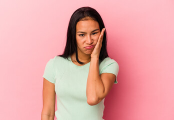 Young Venezuelan woman isolated on pink background who feels sad and pensive, looking at copy space.