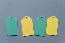 Wooden Pastel Yellow And Green Chalkboard Tags On A Solid Gray Paper Background