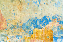 On A Fragment Of A Plastered Wall, Layers Of Old Paint Of Different Colors Are Visible: Yellow, Red, Blue. Areas Of Irregular Shape Resemble A Geographic Map. Background. Texture.