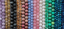 Beads From Various Types Of Natural Stones Are Strung On A Thread.