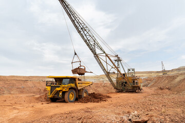 Wall Mural - large excavator loads rock with iron or bauxite mining