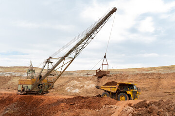 Wall Mural - large excavator loads rock with iron or bauxite mining