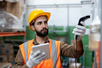 Gloved engineer or logistics manager scanning packed goods in warehouse