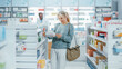 © Gorodenkoff - Pharmacy Drugstore: Portrait of a Beautiful Senior Woman Choosing to Buy Medicine, Drugs, Vitamins. Apothecary Full of Health Care Products, Supplement Bottles, Beauty Packages with Modern Design