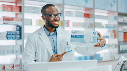 Wall Mural - Pharmacy Drugstore: Portrait of Professional Black Male Pharmacist Holding Box with Best Deal Face Masks, Looking at Camera, Smiling. Specialist Recommending Best Product