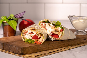 Homemade shawarma or burrito or chicken roll with vegetables and sauce