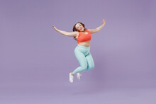 Full Length Young Chubby Overweight Plus Size Big Fat Fit Woman Wear Red Top Warm Up Train Jump High With Outstretched Hands Isolated On Purple Background Home Gym. Workout Sport Motivation Concept