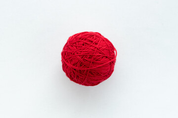 Wall Mural - One round ball of red color in the center of the frame on a white woven background on the theme of handmade hobby knitting