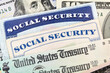 © trekandphoto - Macro view of Social Security cards, United States Treasury checks and cash.