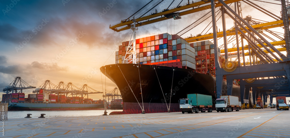 crane loading cargo container from truck to container ship in the ...