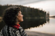 © Maskot - Kvinnlig utforskare tittar ut över sjö i skog
