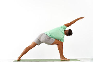 back view of sporty man practicing yoga in yoga class, making stretching back. Healthy lifestyle, Yoga Practice Exercise Class Concept