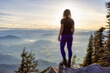 © edb3_16 - Adventurous Caucasian Adult Woman hiking in Canadian Nature over looking mountainous landscape. Sunset Sky. Elk Mountain Hike in Chilliwack, East of Vancouver, BC, Canada.