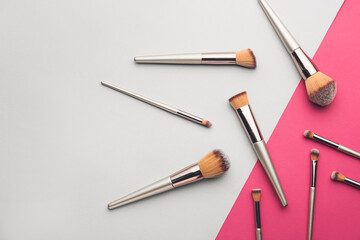 Set of makeup brushes on color background