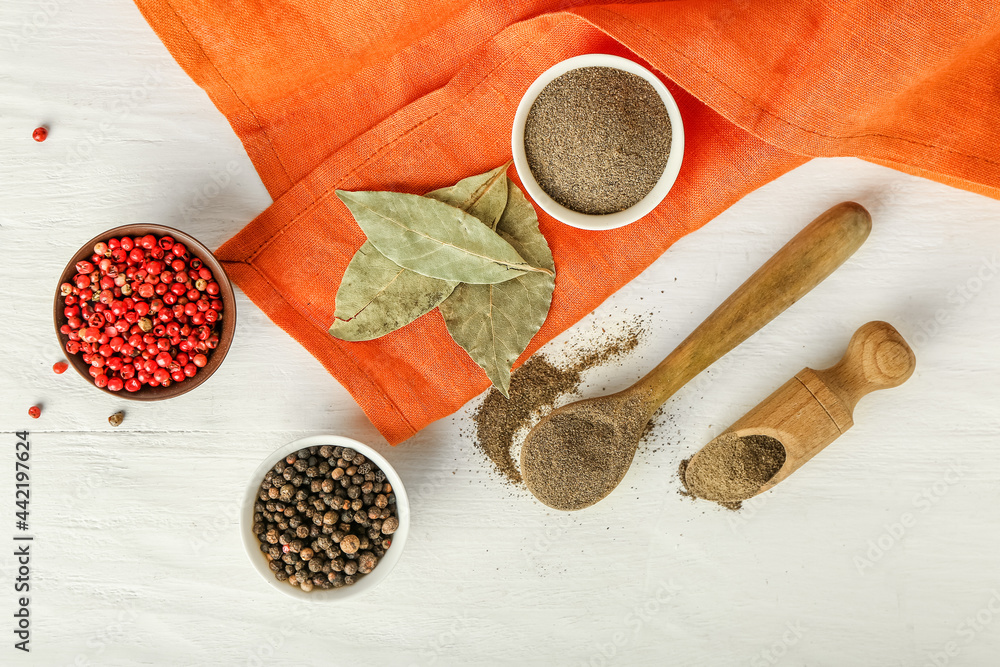 Composition with different types of pepper on light wooden background