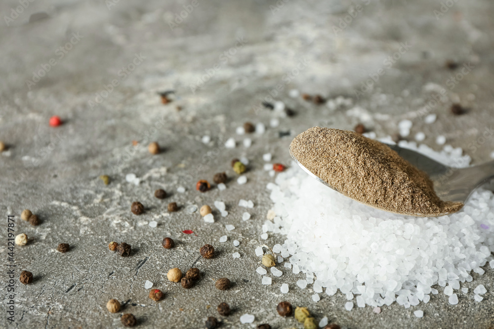 Spoon with black pepper powder on grunge background