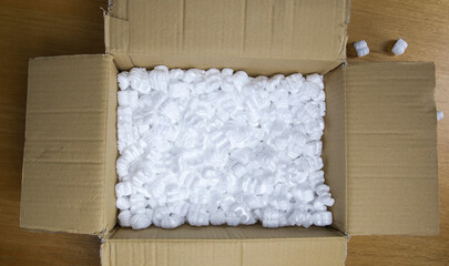 A cardboard box with packing foam top view, Delivery box for fragile product on wooden table