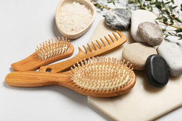 Composition with hair brushes, comb, sea salt and spa stones  on light background