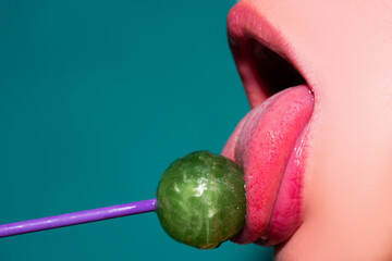 Wall Mural - Glamor mouth licking yummy lollypop with red lips. Sucks lolli pop. Sexy female lip. Sensual woman red lips with a Lollipop. Candy bar concept.