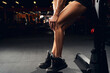 Strong muscular lady touching her knee at the gym