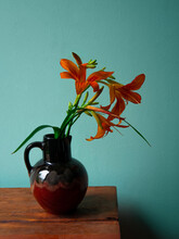 Tiger Lily In Ceramic Vase With Shadow Turquoise Wall Background. Lilium Lancifolium Orange Flowers Bouquet On Wooden Farmhouse Table. Summer Cottagecore Aesthetic Country Rural Minimalism Dark Style.