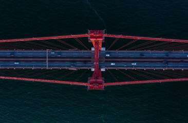 Aerial birds eye overhead top down view of cars driving on multilane road suspension bridge over Tagus river. Lisbon, Portugal.