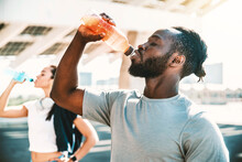 Fitness african athlete drinking energy drink outdoor - Fit people resting taking a break after workout - Healthy lifestyle concept