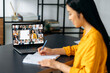 © Kateryna - Online education. Smart japanese student girl gains knowledge watching lesson online. Young woman takes notes during webinar, listening lecture on video call. Female teacher and students on a screen