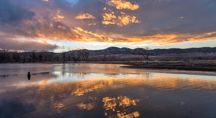 Wall Mural - Burning Sky - Colorful sunset clouds hovering over a half-frozen bay of Chatfield Reservoir on a calm Winter evening. Chatfield State Park, Denver-Littleton, Colorado, USA.