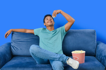 African-American teenager eating popcorn at home