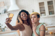 © zinkevych - Dark-skinned woman with smartphone in outstretched hand and girlfriend