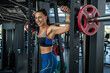© nazarovsergey - Cheerful fit young brunette standing near Smith machine at gym